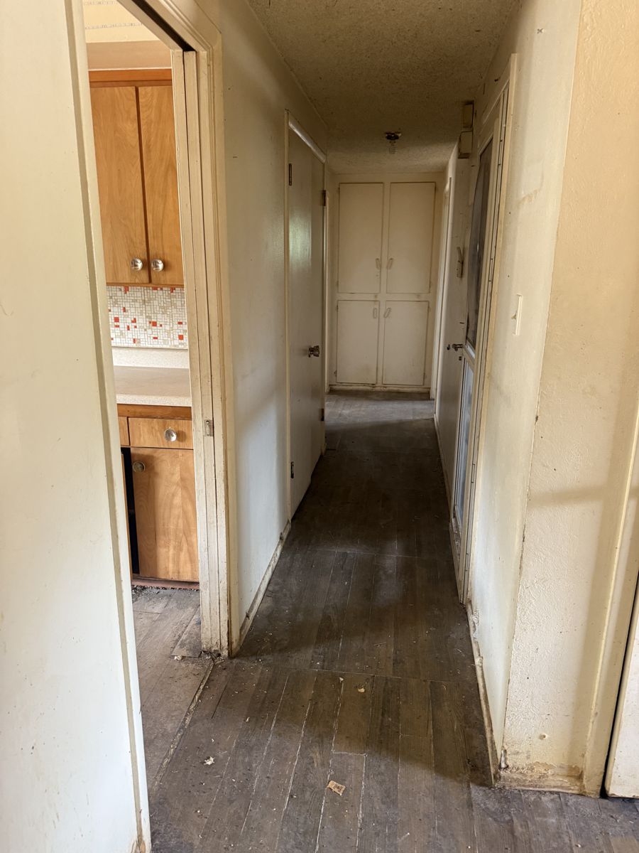 Hallway with worn floors in a Reno 89519 house bought as-is