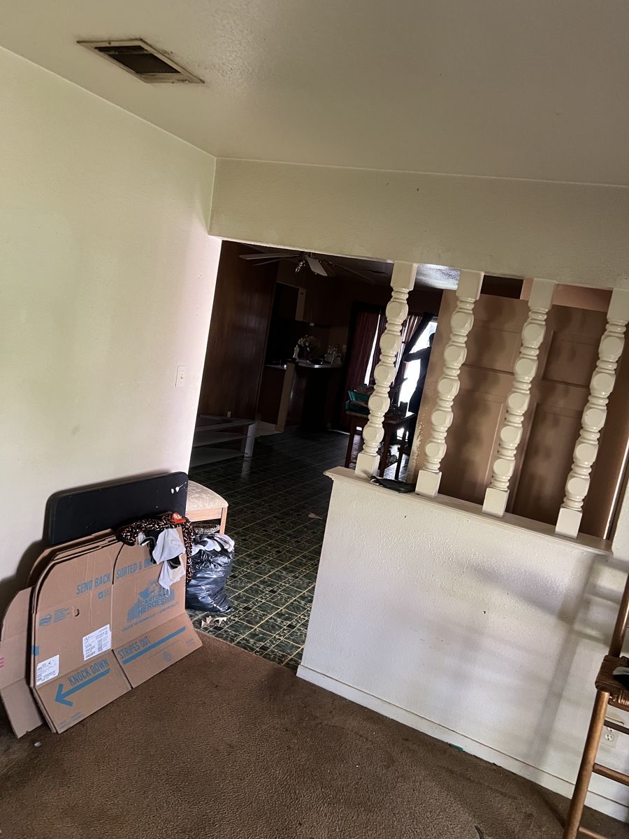 Living area with belongings left behind in a Houston 77091 house bought as-is